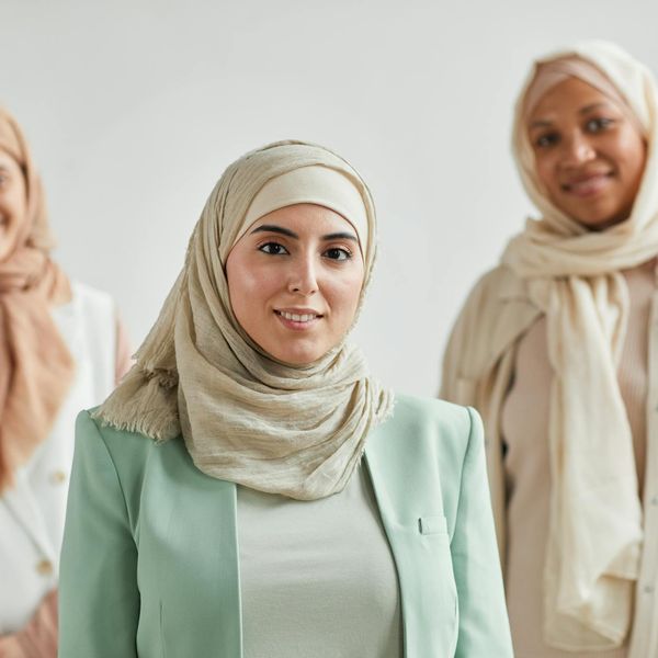 Diverse group of people smiling in a bright, modern yoga studio.